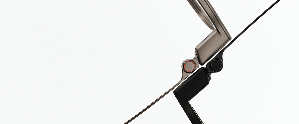 Close-up of the RayNeo iO hinge showing a rotating dial control (the Smart Crown) with a red accent ring, next to the temple arm.