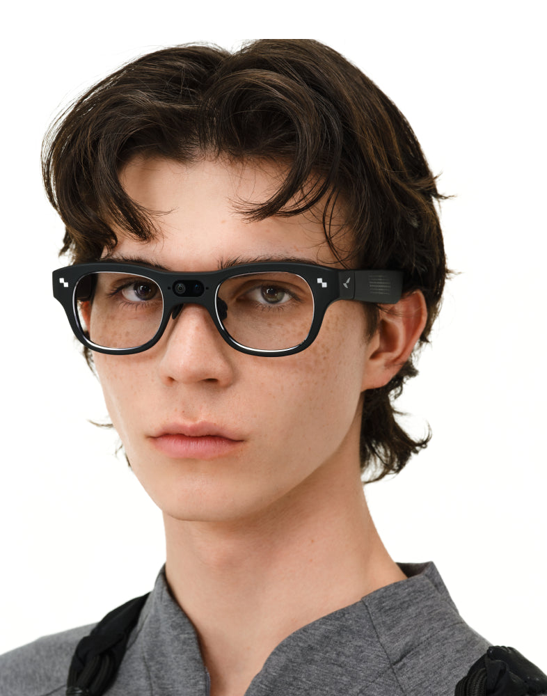 RayNeo X3 Pro smart glasses worn by a young man, with the front camera visible against a white background.